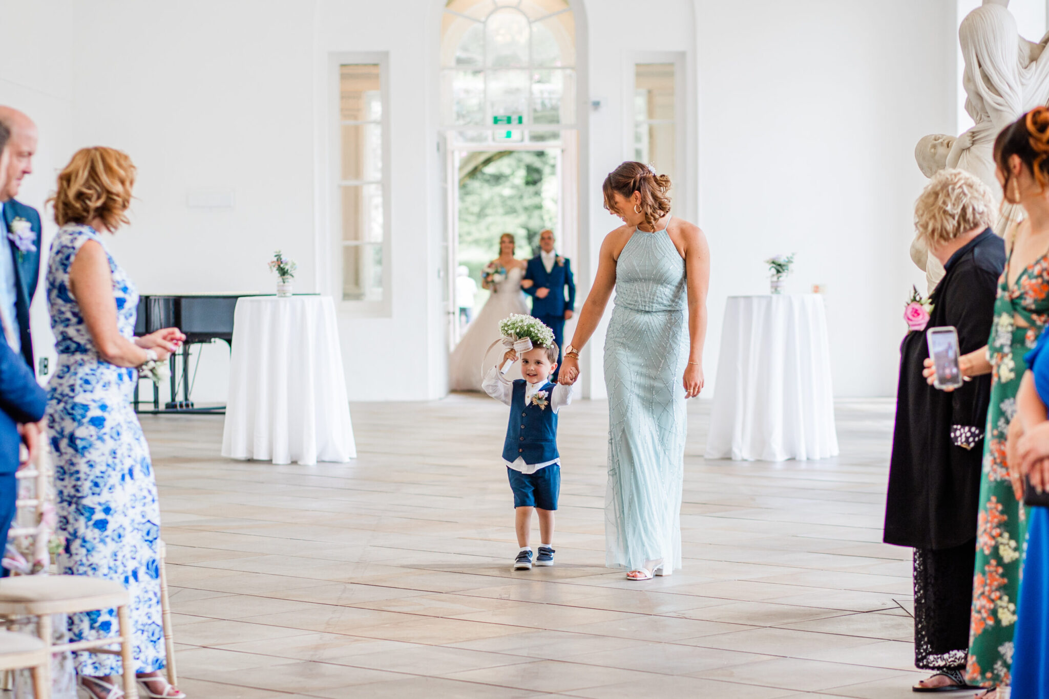 Bridesmaid and page boy entering wedding ceremony